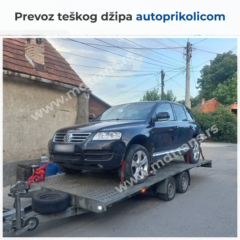 Težak džip postavljen na autoprikolicu za prevoz